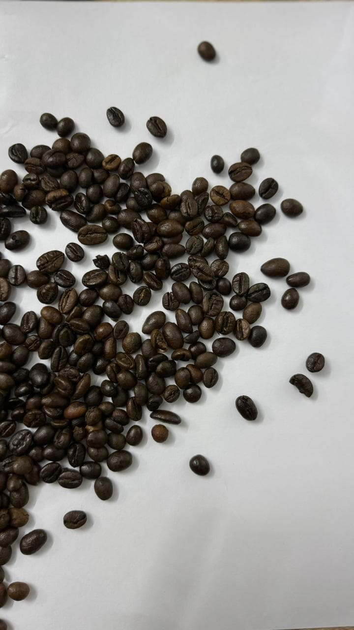 Espresso roast beans sprinkled across a burlap cloth.